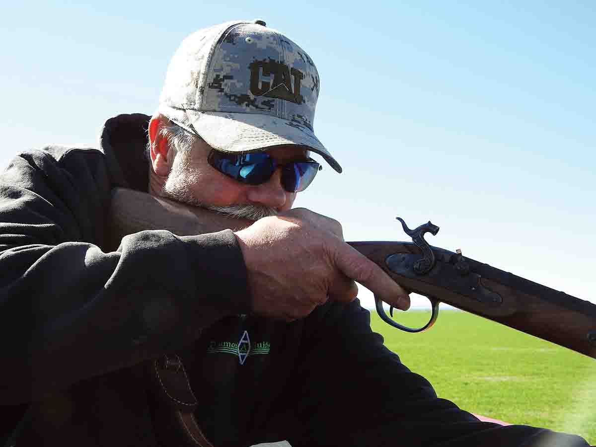Justin Aamodt, shooting from a raised platform, sights-in on a sage rat in orchard grass. A small caliber muzzleloader like this .32-caliber Crockett is a good choice for alfalfa-munching squirrels and other varmints.